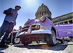 Low angle shot of The Capitolio with classic American car and old man in foreground, Havana, Cuba, West Indies, Caribbean, Central America