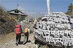 Randonneurs en passant devant une pierre de mani, Solu Khumbu région de l'Everest, Parc National de Sagarmatha (Népal), Asie