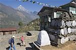 Trekkers walking past a mani stone, Solu Khumbu Everest Region, Sagarmatha National Park, Nepal, Asia