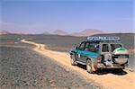 Jeep driving on stone desert, Akakus, Sahara desert, Fezzan, Libya, North Africa, Africa