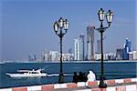 City skyline and the famous Corniche looking across the harbour from a pier, Abu Dhabi, United Arab Emirates, Middle East