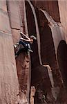 Un grimpeur s'attaque à une fissure en surplomb dans un mur de grès sur les falaises de Indian Creek, un célèbre rocher d'escalade dans le Parc National de Canyonlands, près de Moab, Utah, États-Unis d'Amérique, Amérique du Nord
