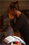 Candle and Bible, with woman praying in the background, Saint Nicolas de Veroce, Haute Savoie, France, Europe