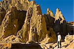 Man walking through strange looking sandstone formations, Ankarafantsika National Park, Madagascar, Africa