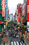 Une rue piétonne bordée de boutiques et de panneaux de signalisation attire une foule à Shinjuku, Tokyo, Japon, Asie