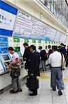 Former les passagers achetant les billets dans des distributeurs automatiques à la gare JR Ueno à Tokyo, Japon, Asie