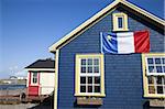 Acadian flag on blue house in La Grave, Ile Havre-Aubert, one of the Iles de la Madeleine (Magdalen Islands), Gulf of St. Lawrence, Quebec, Canada, North America