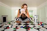 Jeune femme dans une petite salle avec des jeux de cartes et de dés