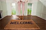 Legs of a woman and welcome mat in small room