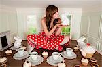 Young woman kissing rabbit at tea party in small room