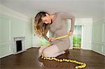 Young woman in small room measuring her waist