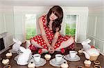 Young woman having tea party in small room