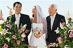 Bride and groom with father, outdoors