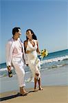 Braut und Bräutigam zu Fuß am Strand