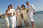 Two newly wed couples and a best man at ocean, (portrait)