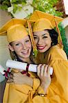 Two graduates hugging outside, portrait