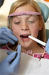 Girl (7-10) having teeth examined at dentists, (close-up)