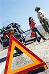 Warning triangle behind police motorcycle and stopped car