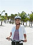 Haute femme à vélo sur la plage tropicale