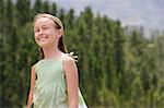 Girl (7-9) with forest in background, smiling.