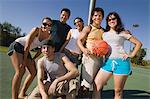 Group of young adults at basketball court.