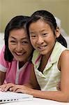 Mother and Daughter in living room Using Laptop Together, portrait