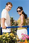 Young couple looking at potted flowers in garden centre