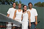 Mixed Doubles Tennis Players standing at Net, arms around