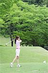 Woman Playing Golf On Golf Course