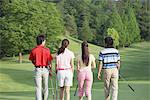 Männer und Frauen zu Fuß auf dem Golfplatz