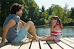 Father and daughter on jetty in lake