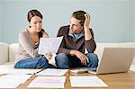 Young couple using computer and doing paperwork