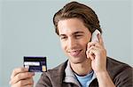 Young man on the phone with credit card