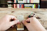 Person holding matchbook with phone number written on it