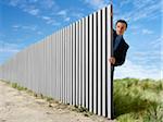 Businessman Peeking Out from Behind Eternal Fence