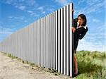 Businesswoman Peeking out from Behind Eternal Fence