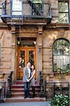 Couple Standing on Stairs in front of Building