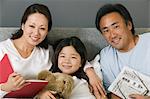 Family Relaxing Together in Bed reading, portrait