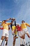 Soccer players jumping for ball, low angle view