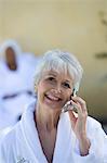 Portrait of senior woman in bathrobe using mobile phone