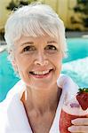 Portrait of senior woman holding strawberry cocktail