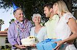 Deux couples sur la fête d'anniversaire dans le jardin, souriant