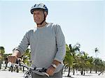 Senior homme à vélo sur la plage tropicale