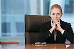 Businesswoman sitting at conference table, portrait