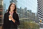 Office worker with drink outside office building, portrait