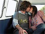 Young couple kissing in back of van