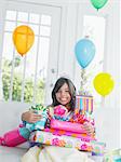 Portrait of young girl (7-9) with birthday presents, smiling