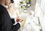 Groom putting a ring on bride's finger