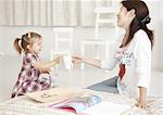 Girl passing a cup to mother