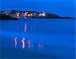 Lumières de St. Ives qui se reflètent dans les vagues, juste avant l'aube, Porthminster beach, Cornwall, Royaume-Uni